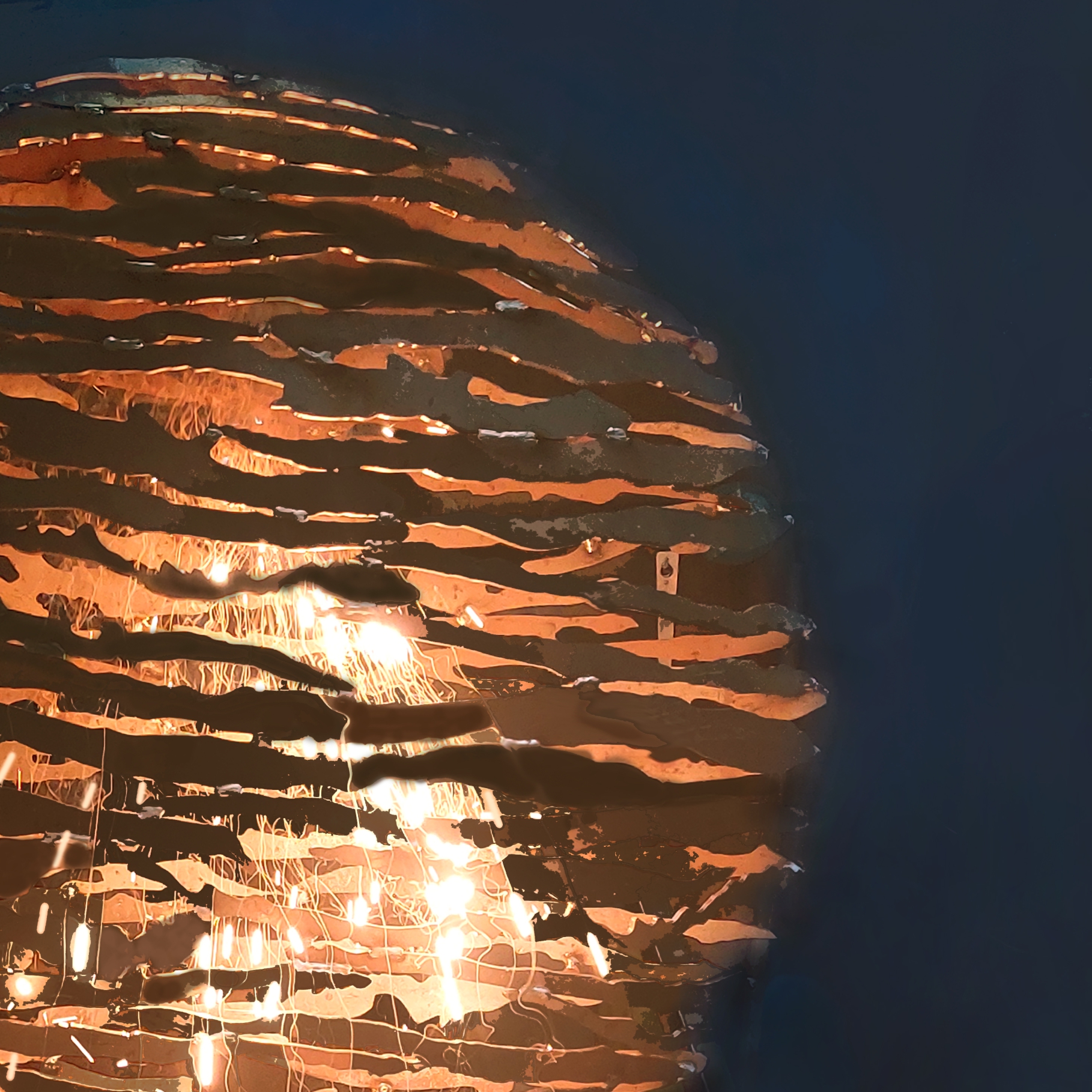 Stalen beeld met organische uitsparingen dat wordt gelast, met oranje gloed op donkere achtergrond.