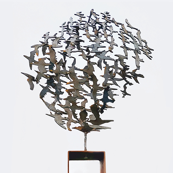 Vlucht is een beeld in Cortenstaal van vogels op stalen sokkel