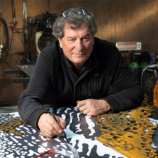 Marco Käller aan het werk met een cortenstalen beeld.